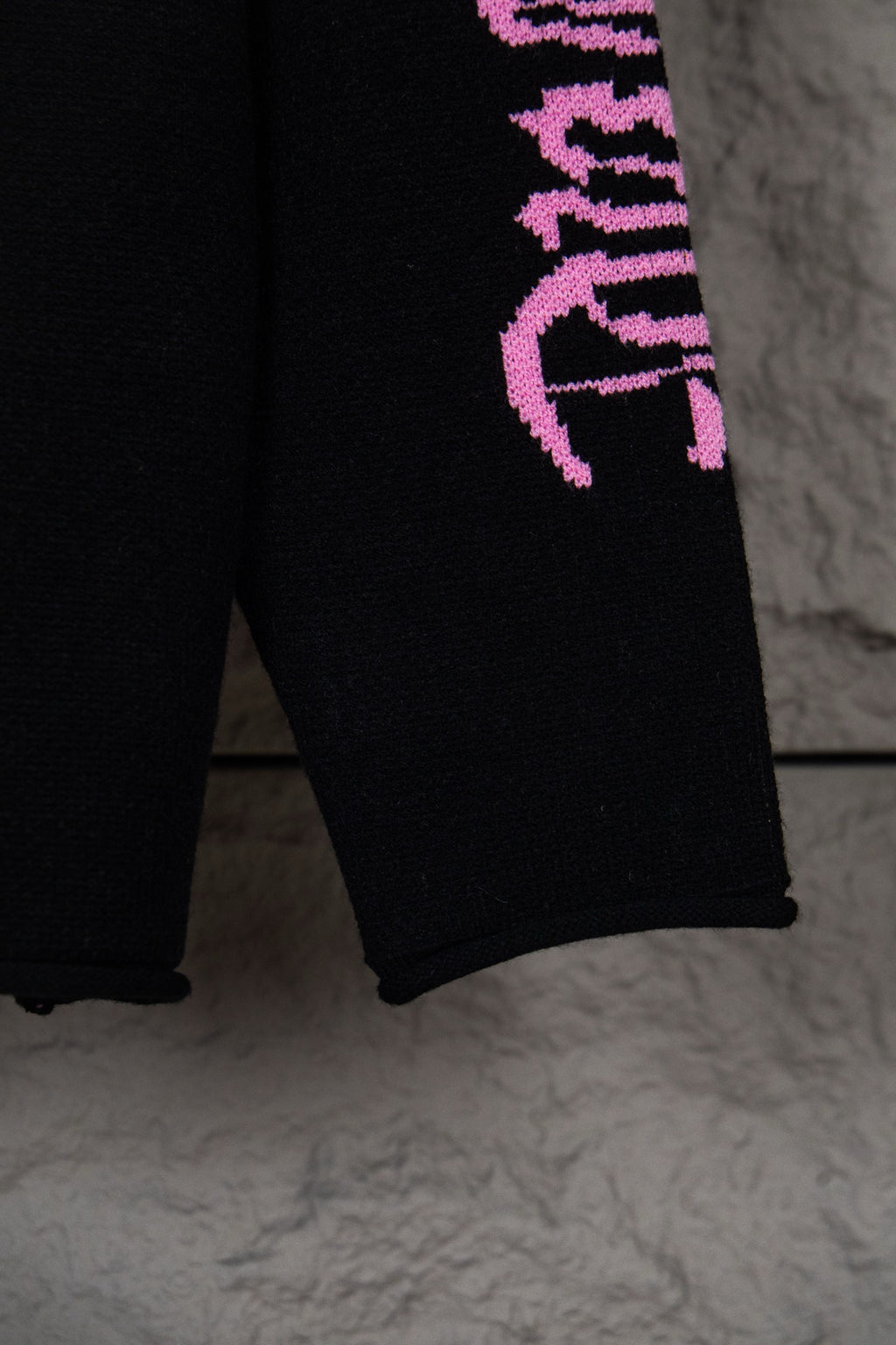 Black sweatshirt lower sleeve with purple vertical “Chrome Records” lettering
