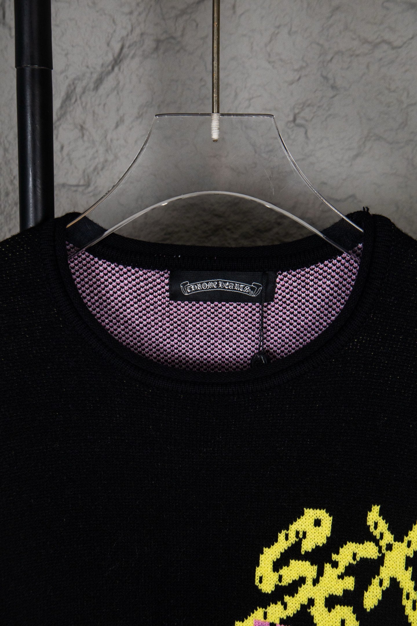 Black long-sleeve sweatshirt neckline with purple check inner collar and neck tag