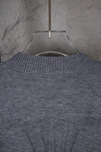 Gray knit sweater upper back with ribbed neckline and central seam
