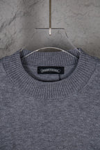 Gray crew-neck knit sweater with black interior neck label