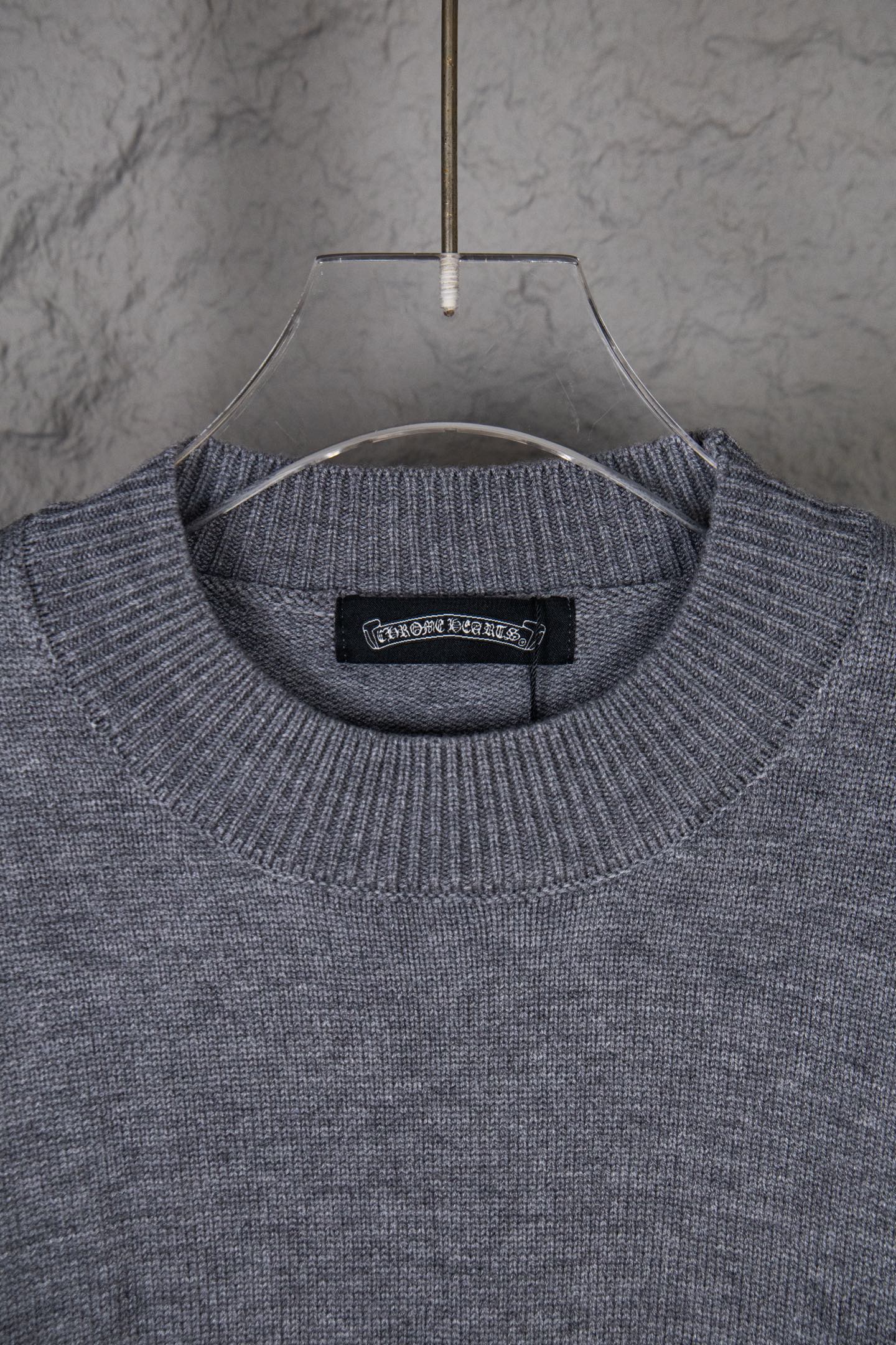 Gray crew-neck knit sweater with black interior neck label