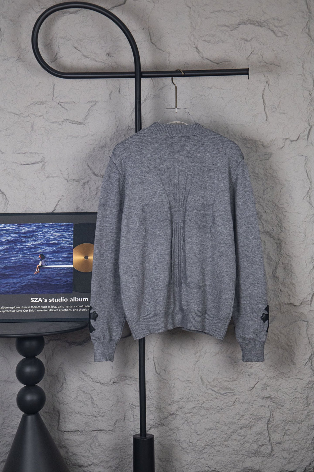 Gray long-sleeve knit sweater back view on hanger, crew neck and ribbed hem
