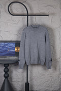 Gray long-sleeve knit sweater on hanger, crew neck and ribbed cuffs