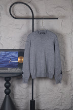 Gray long-sleeve knit sweater on hanger, crew neck and ribbed cuffs