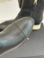 Black leather ankle boot with gold zipper, smooth toe and jeweled heel