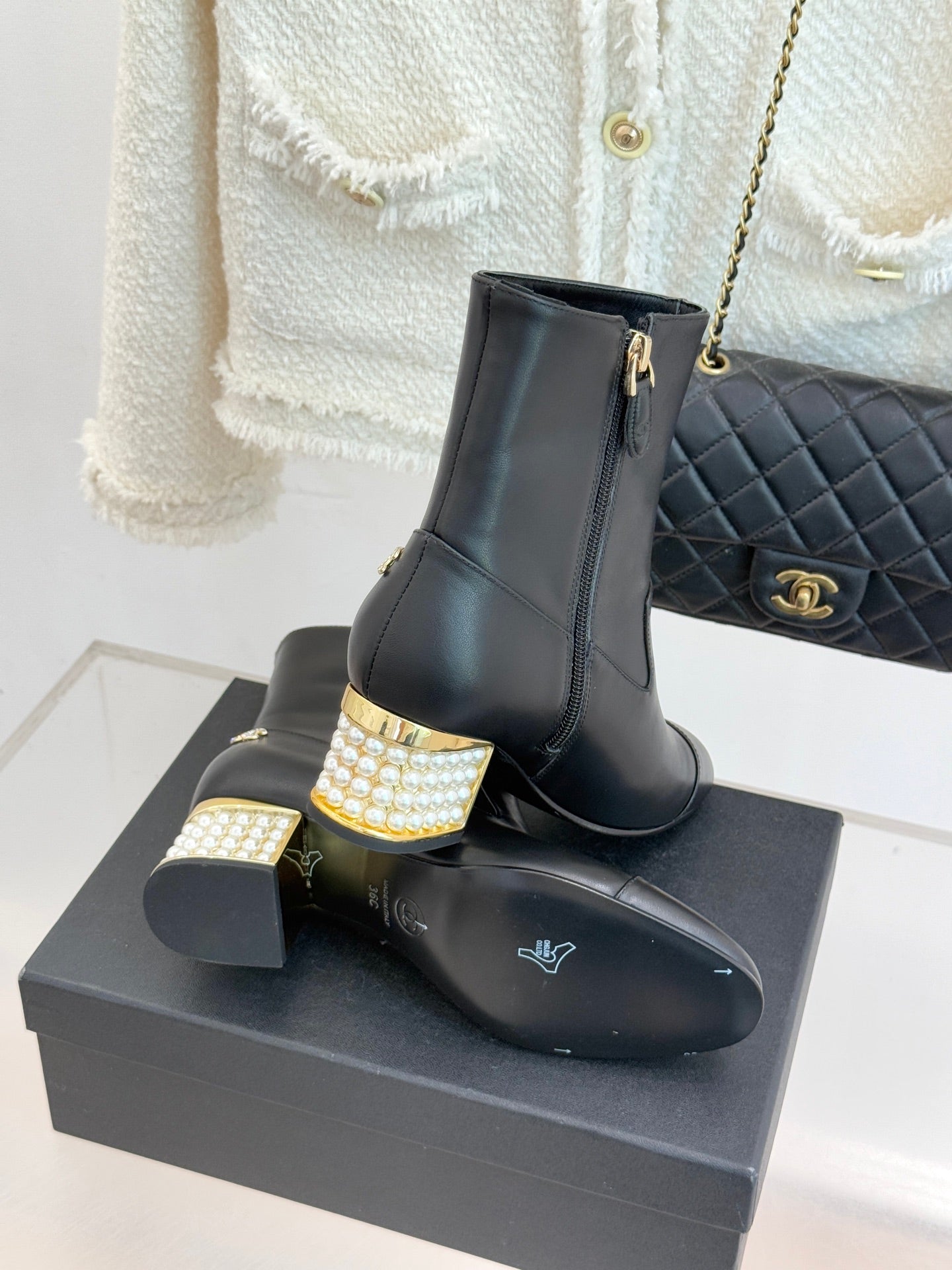 Black leather ankle boot on box with gold zipper, jeweled block heel and Chanel emblem
