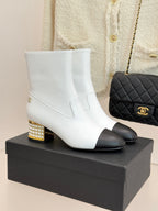 White leather ankle boots with black toe and gold studded block heel