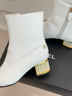 White ankle boot on display with gold studded block heel
