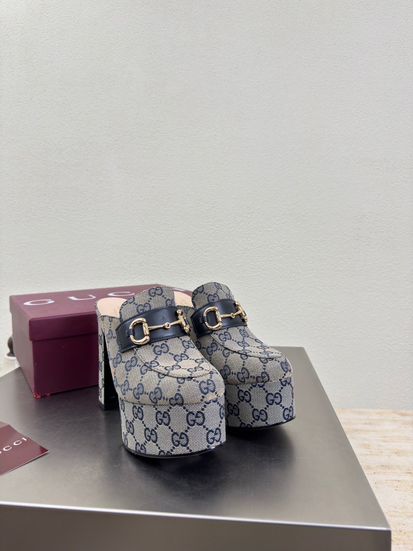 Gucci GG-pattern slip-on mules with gold hardware and black interior lining