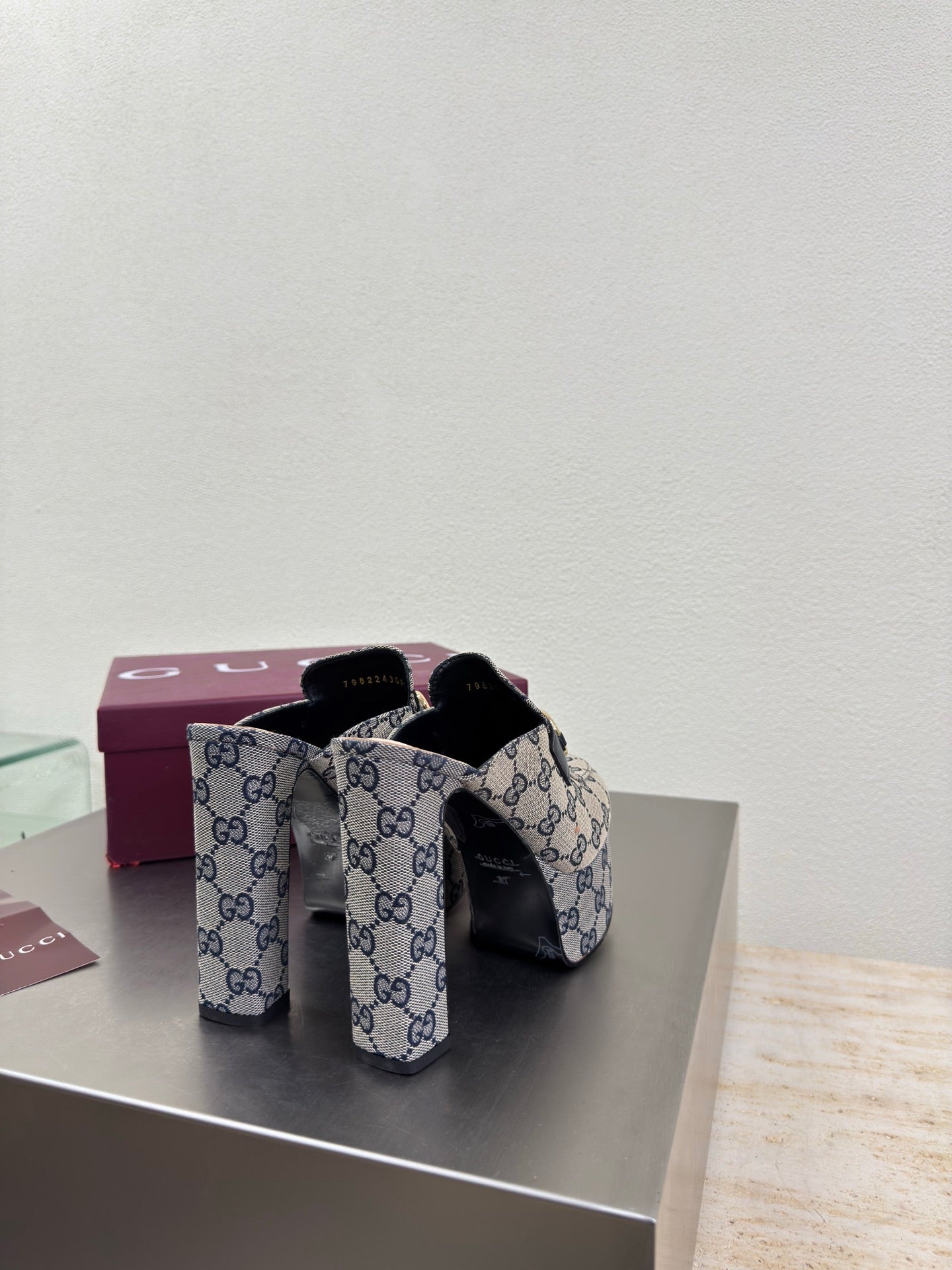 Gucci GG-pattern mules showing side profile and gold horsebit buckle detail