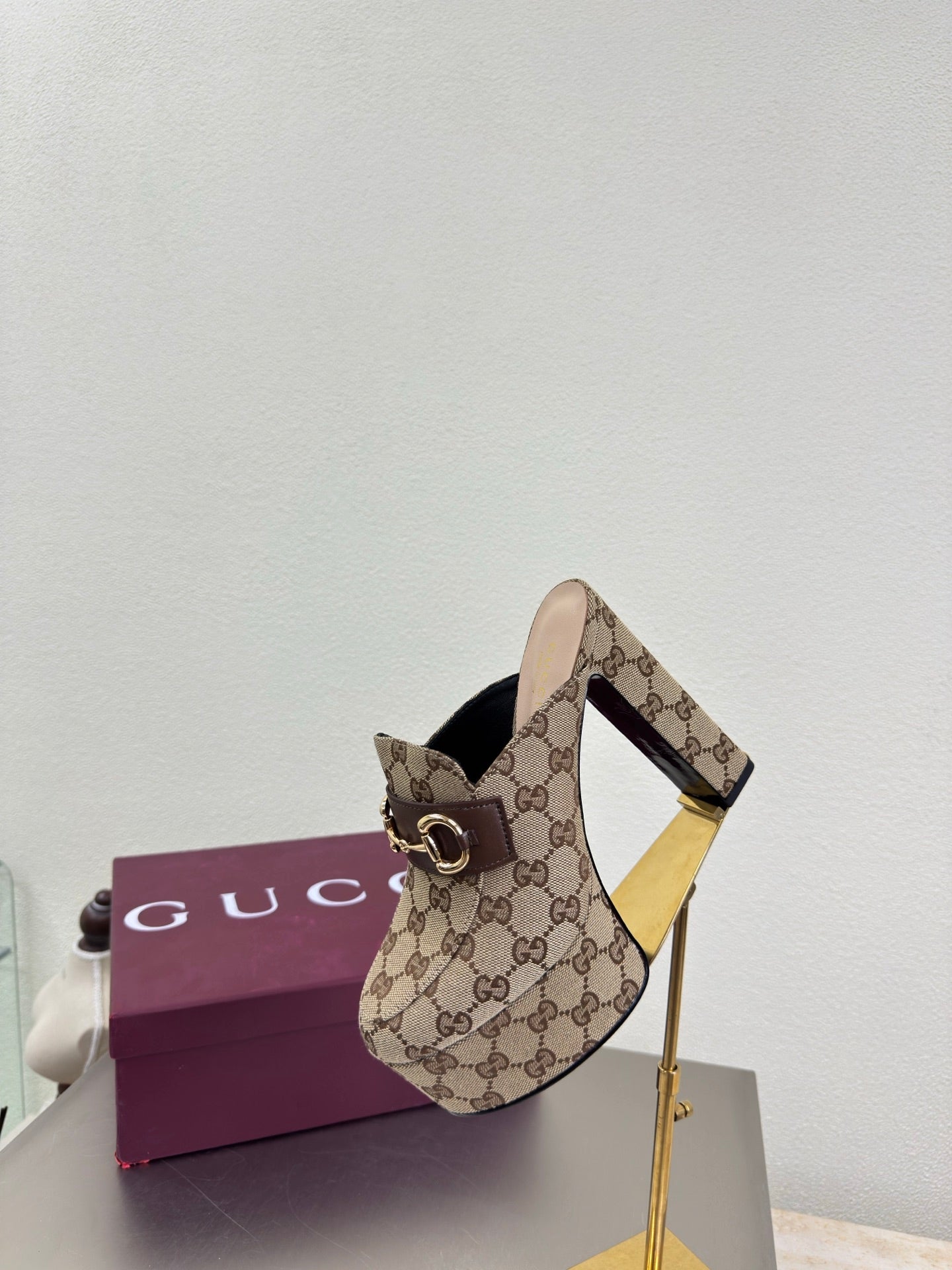 Gucci GG canvas mule loafer with gold-tone horsebit, angled profile view