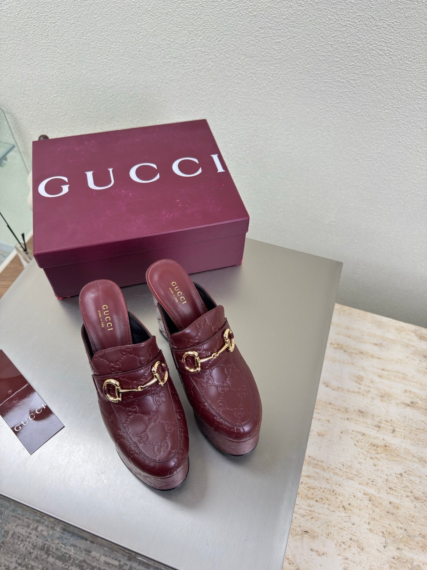 Burgundy Gucci heeled mules with gold horsebit detail and textured leather