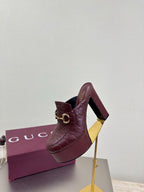 Burgundy Gucci mule with gold horsebit buckle and textured leather, side view