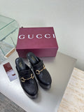 Black Gucci mule with gold horsebit detail and chunky block heel