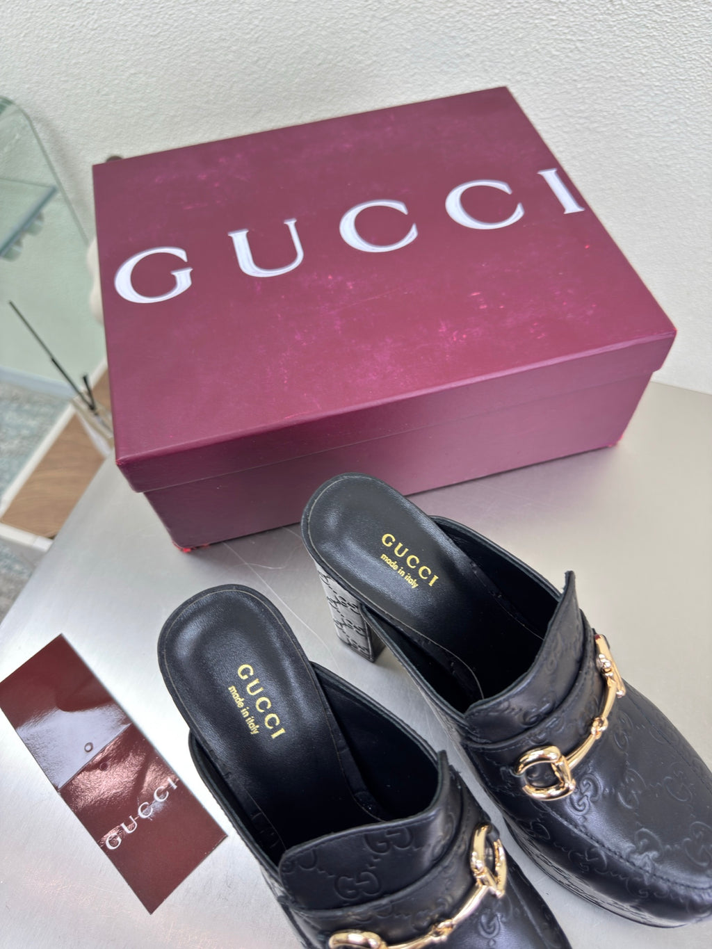 Black Gucci heeled mule with gold horsebit strap and textured leather upper