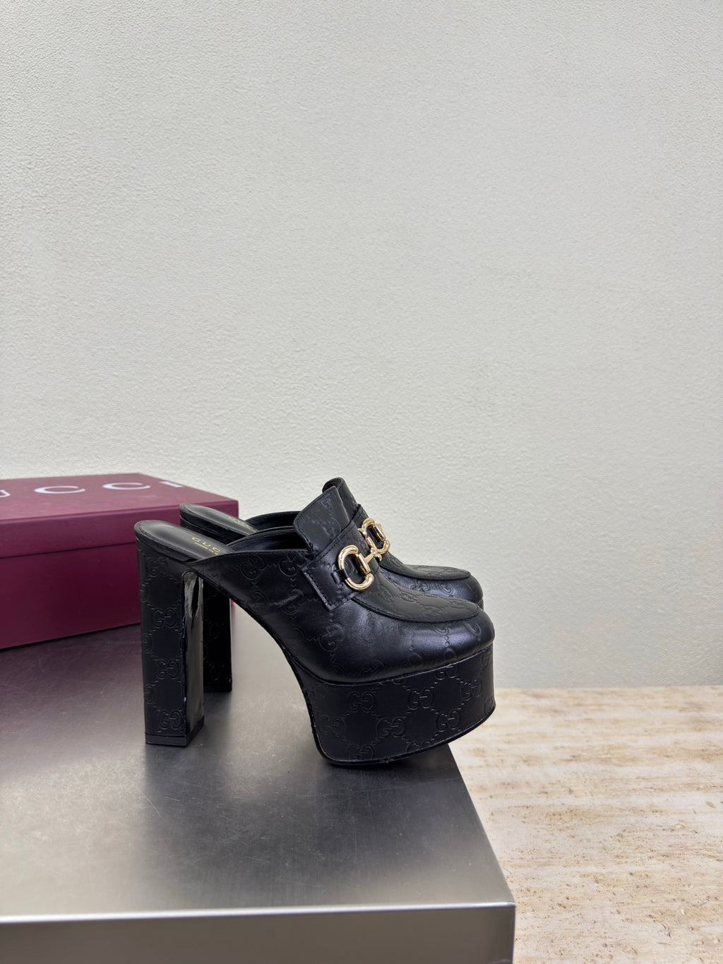 Black Gucci heeled mule with gold horsebit detail and textured upper