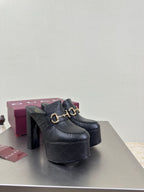 Black Gucci platform mule with gold horsebit bit ornament and thick heel