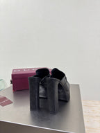 Pair of black Gucci heeled mules with tall block heels and gold hardware