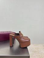 Brown Gucci platform mule with gold buckle, black sole detail, side view