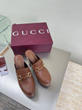 Brown Gucci ladies platform mules with gold buckle hardware and logo texture, pair shown