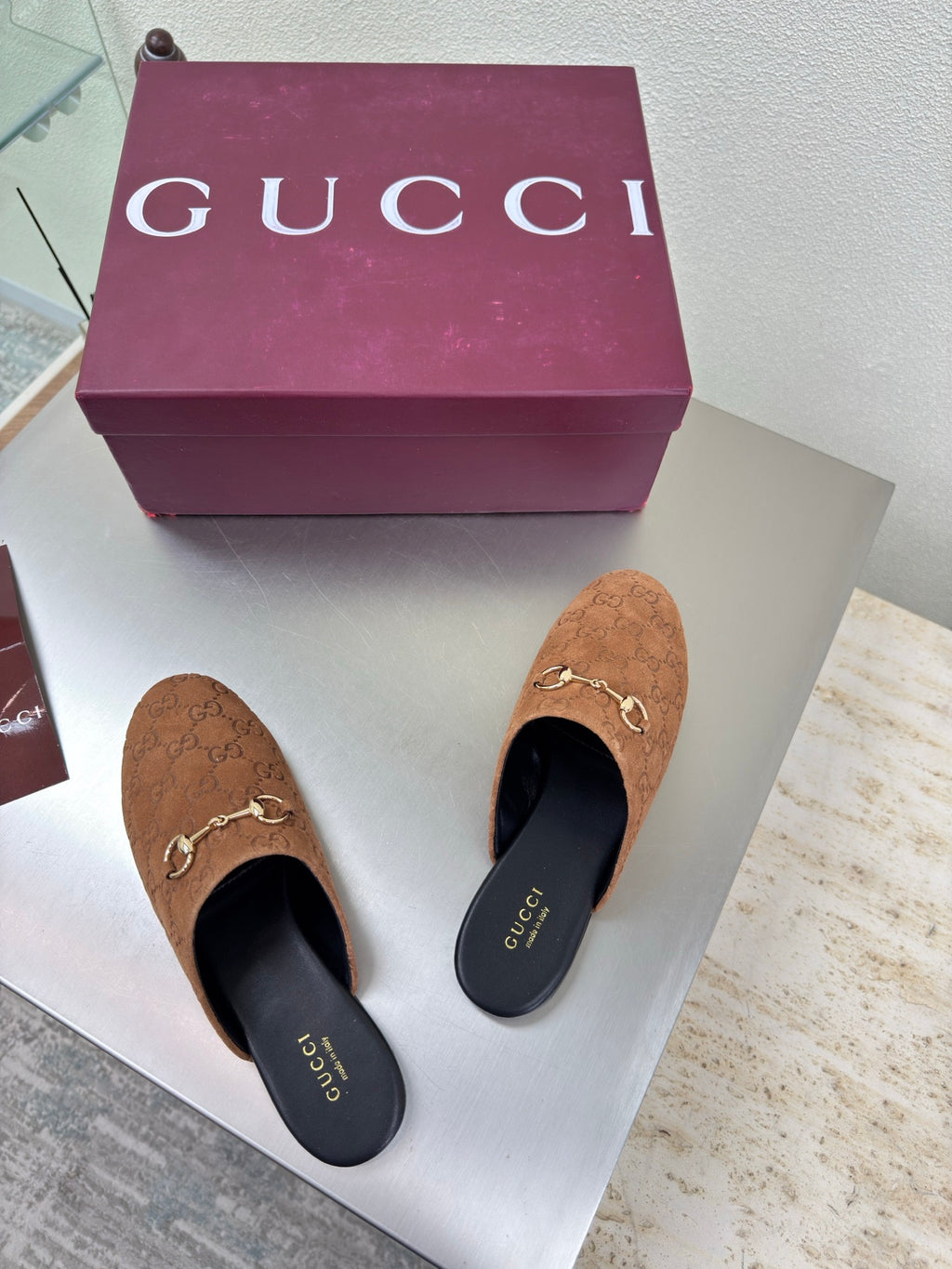 Two women's brown monogram loafers with gold chain bit; black interior lining