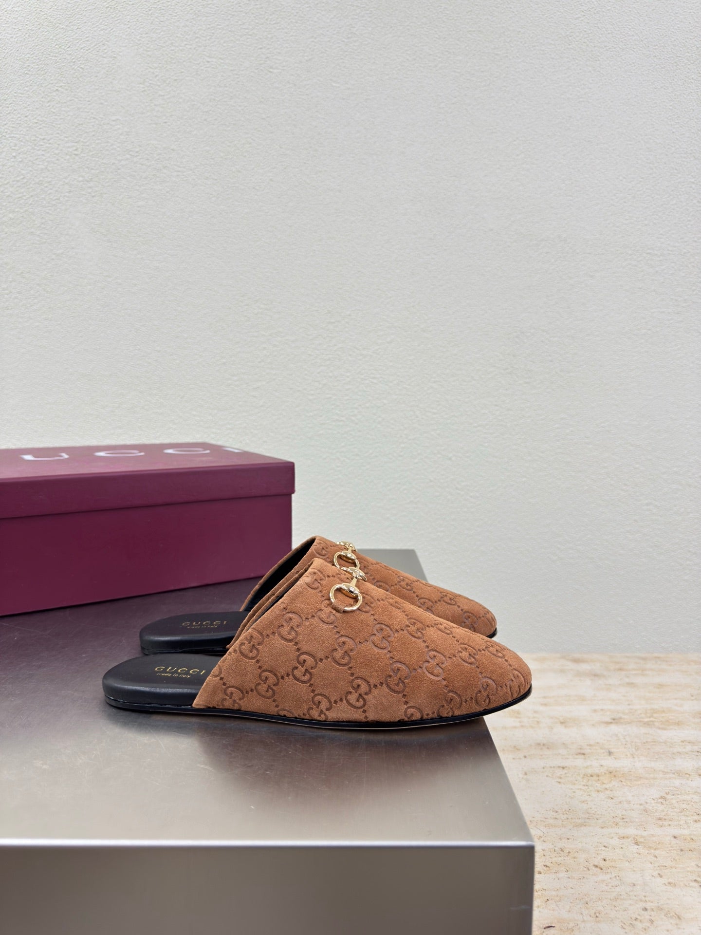 Single women's brown monogram loafer with gold chain bit and black slide sole