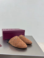 Women's brown monogram loafers with gold chain bit detail on display table