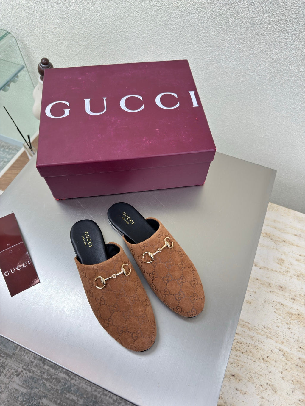 Women's brown monogram loafers with gold chain bit; black interior and sole