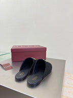 Black Gucci mule shoes with GG logo print and gold horsebit detail, shoes on box