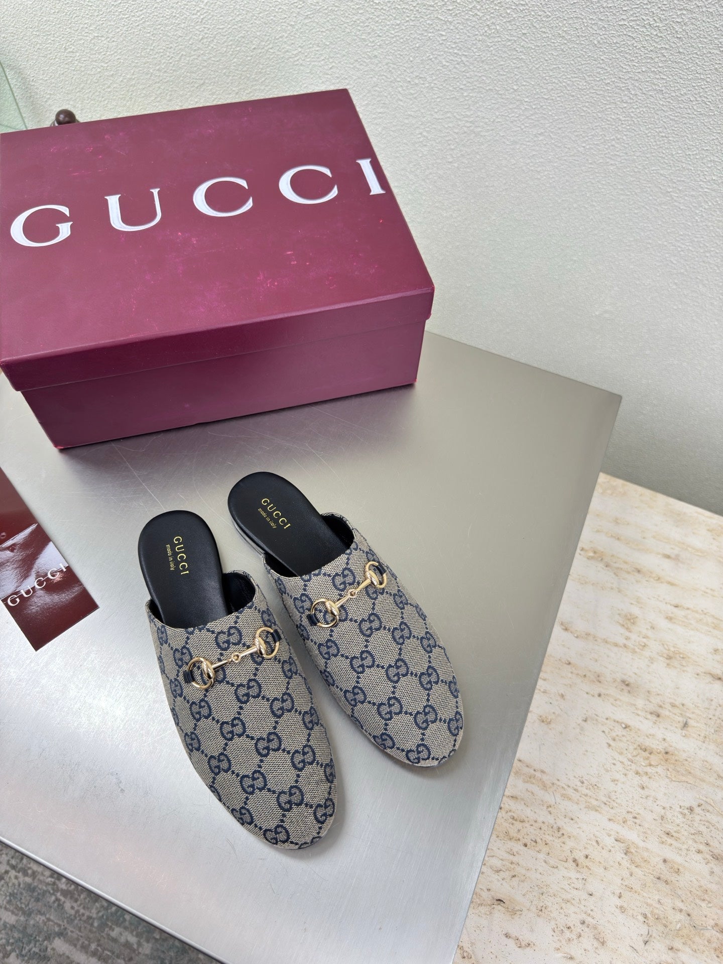 Women’s Gucci GG-pattern slide mules with gold-tone horsebit detail and black insoles
