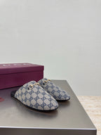 Women’s Gucci GG-pattern slide mules, single pair on display with black outsole