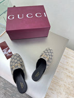 Women’s Gucci GG-pattern slide mules, top view pair with black soles