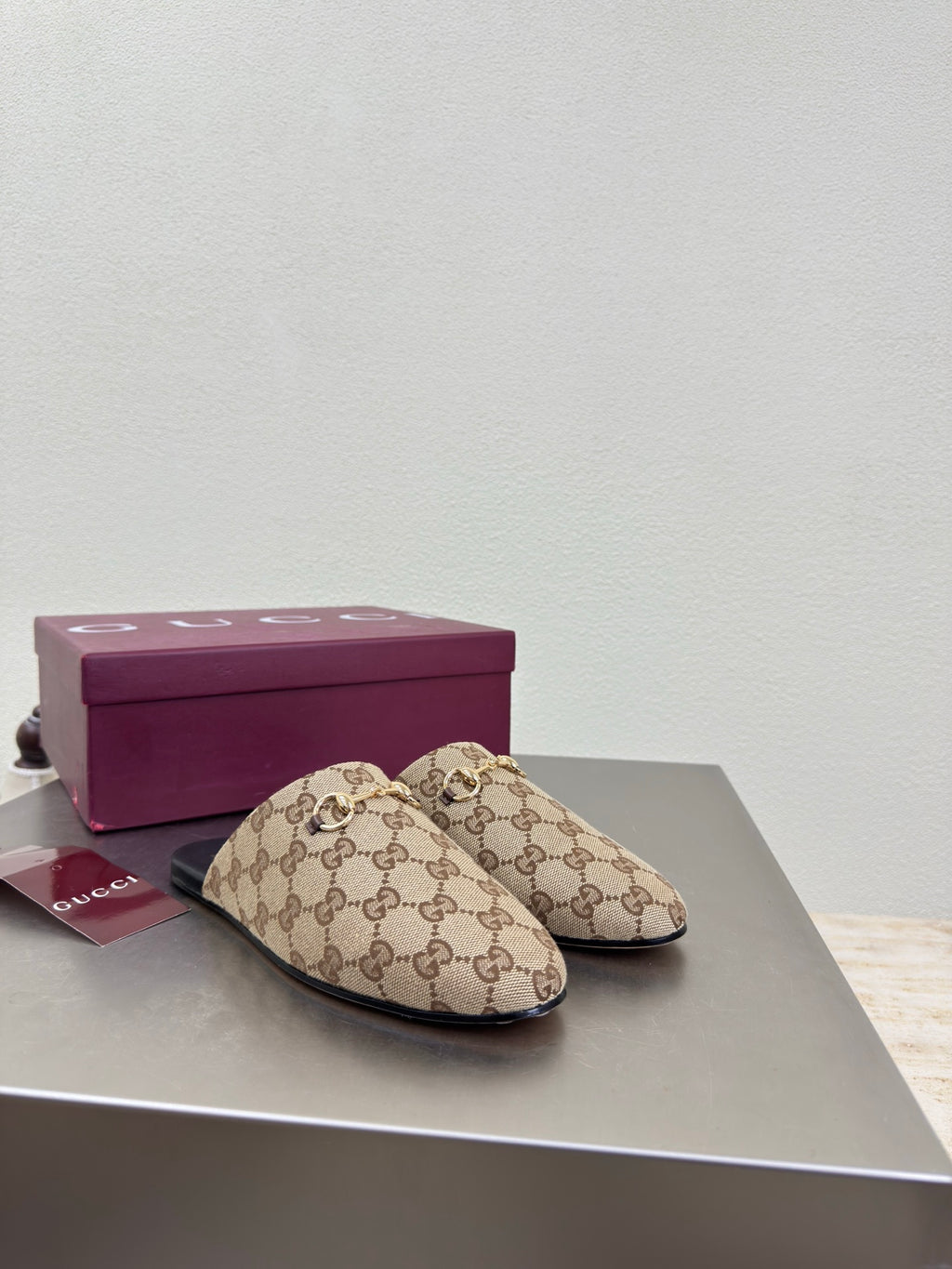 Gucci women’s GG-pattern slip-on loafers, pair on display