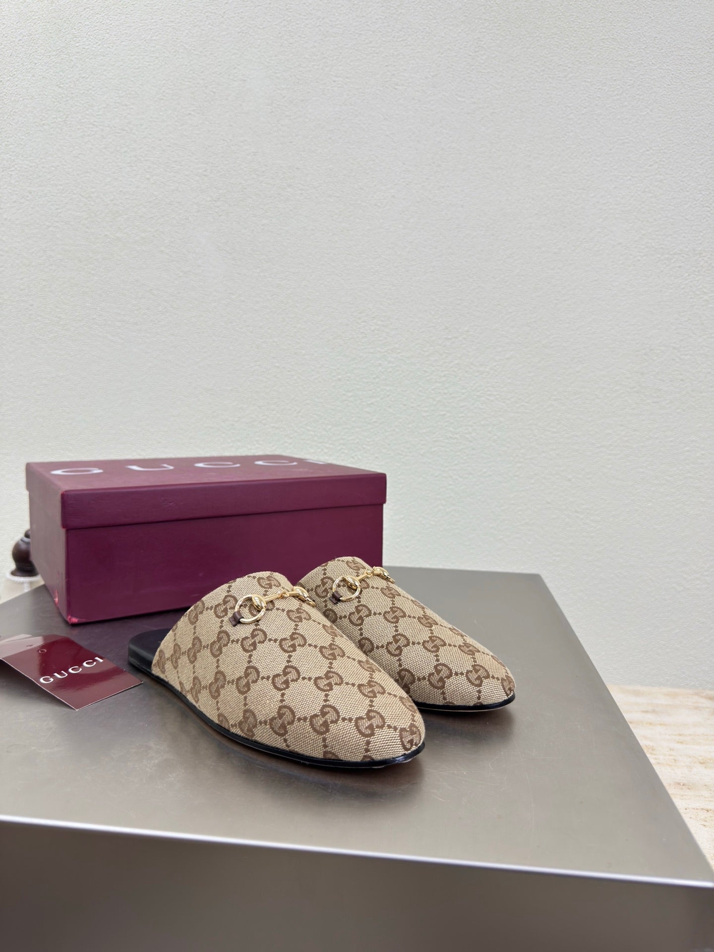 Gucci women’s GG-pattern slip-on loafers, pair on display