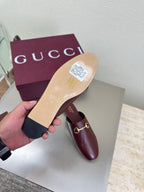 Burgundy leather mule showing light sole bottom and gold horsebit strap detail