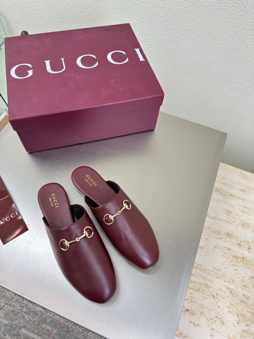 Pair of burgundy leather Gucci mules with gold horsebit detail and open heel