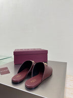 Burgundy leather mules with gold horsebit on the vamp, shown side by side