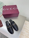 Gucci black leather mules with gold horsebit detail, rounded toe and low heel