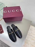 Gucci black leather mules with gold horsebit detail, rounded toe and low heel