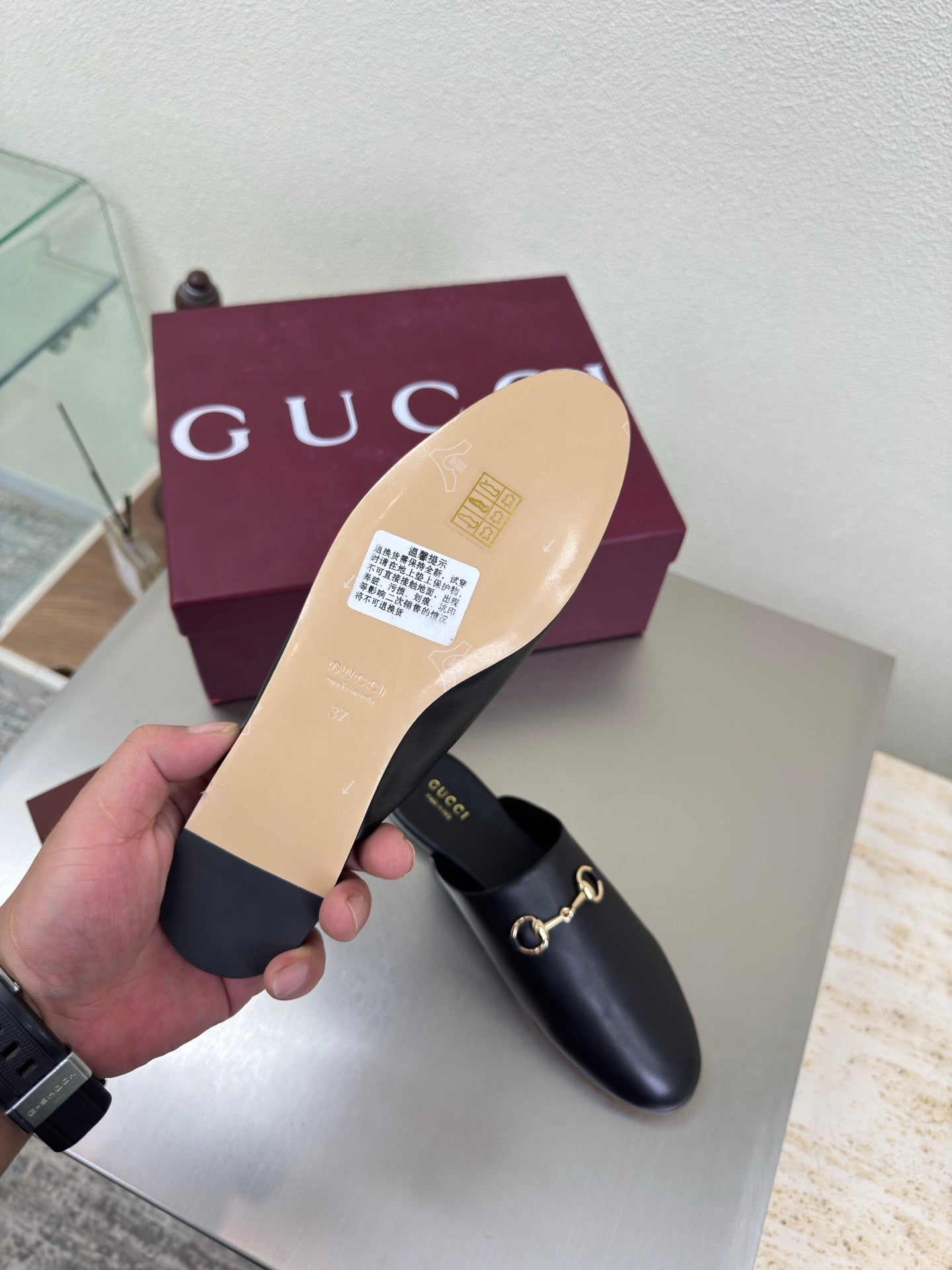 Gucci black leather mule showing tan sole and gold horsebit detail, slip-on