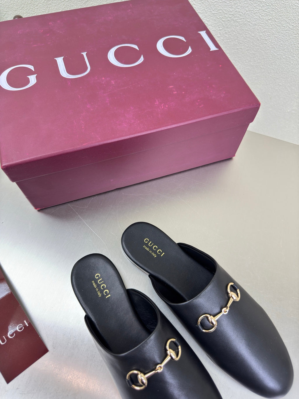 Pair of Gucci black leather mules with gold horsebit trim, slip-on style