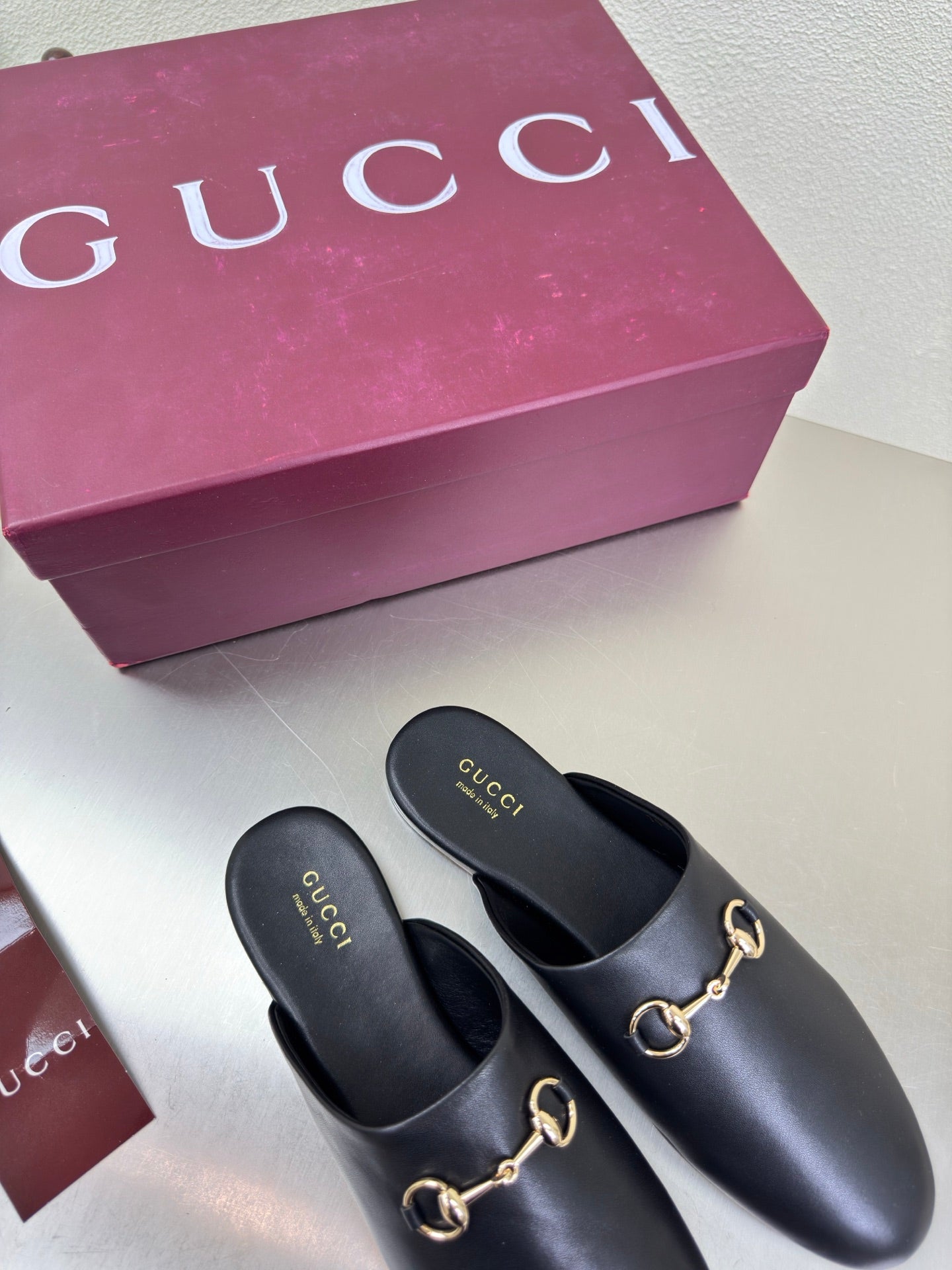 Pair of Gucci black leather mules with gold horsebit trim, slip-on style