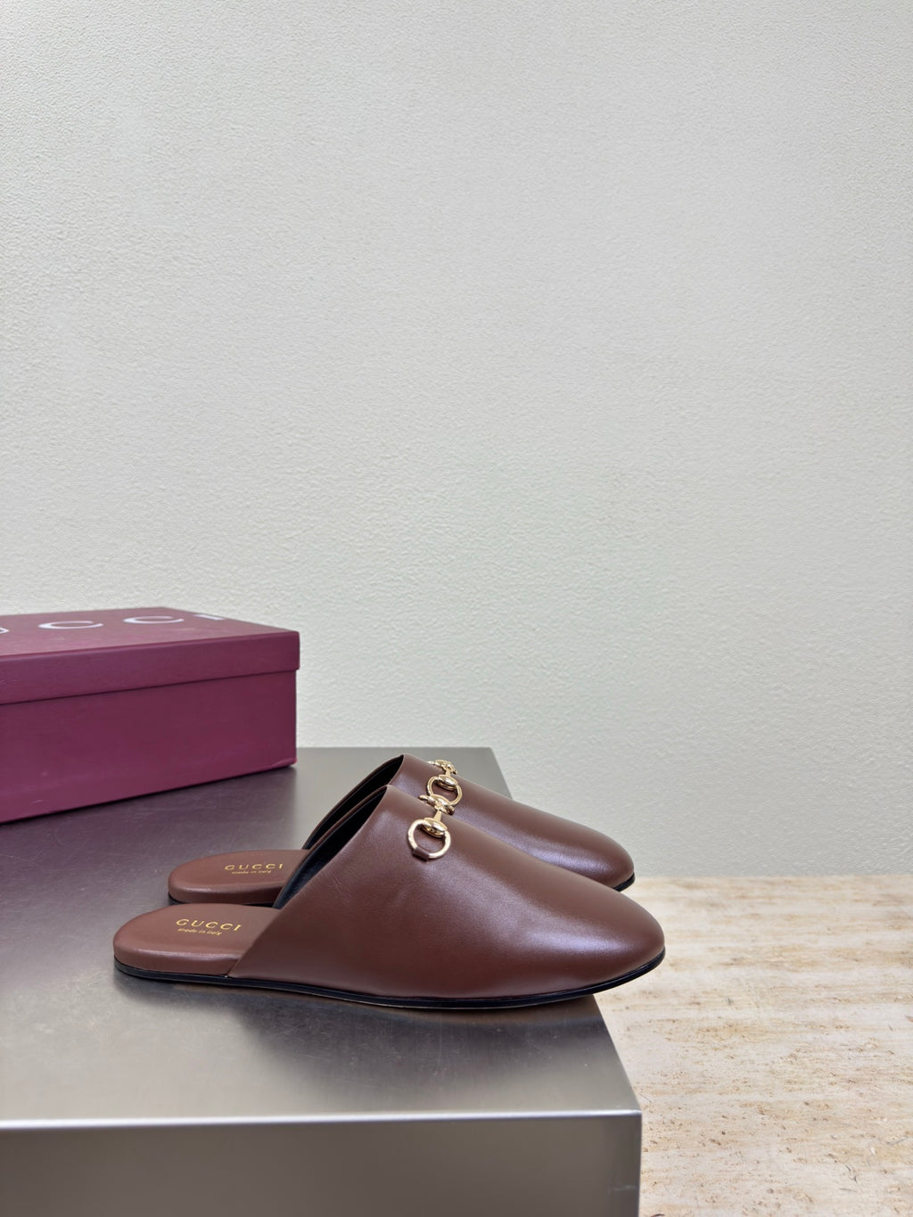 Brown Gucci leather slide mules with gold horsebit on the front