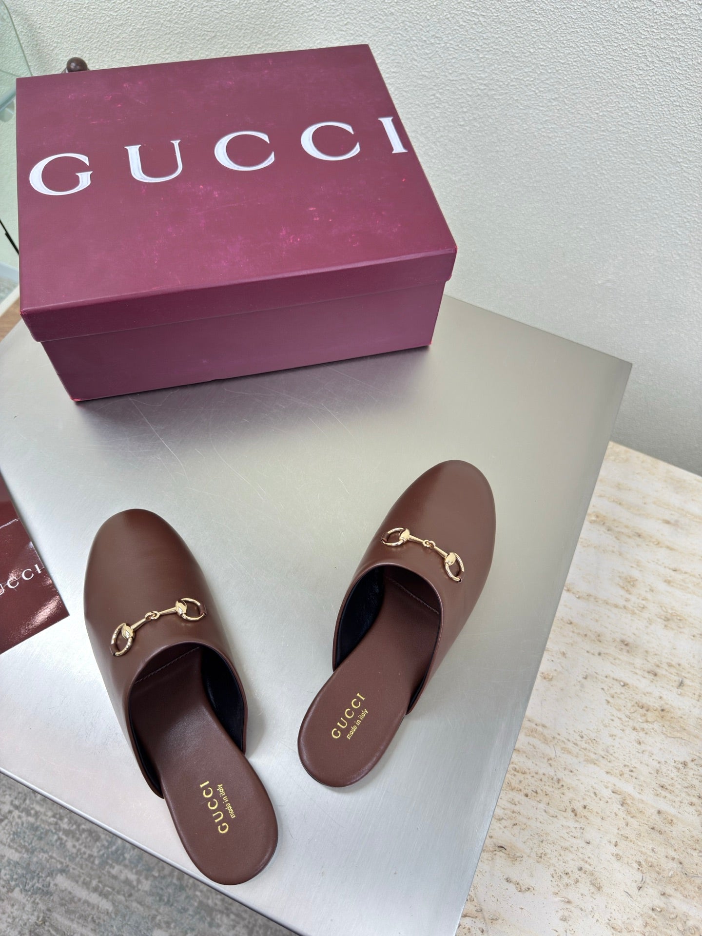 Pair of brown Gucci leather mules with gold horsebit hardware on vamp