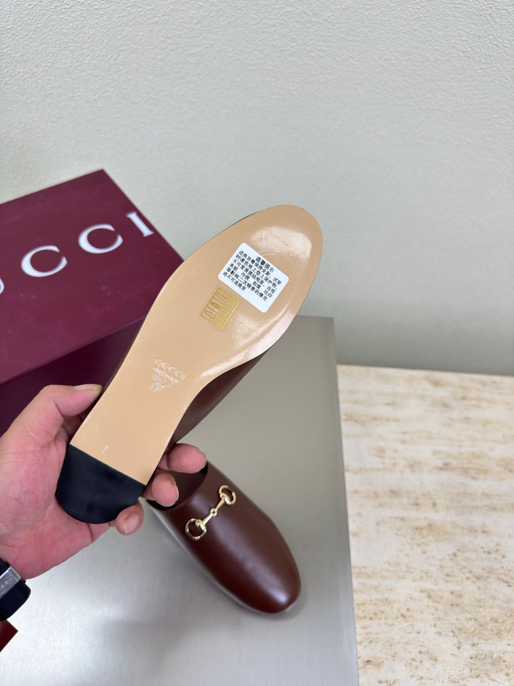Brown Gucci leather mule with branded insole and gold horsebit detail