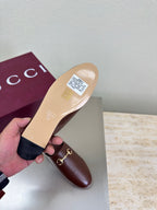 Brown Gucci leather mule with branded insole and gold horsebit detail