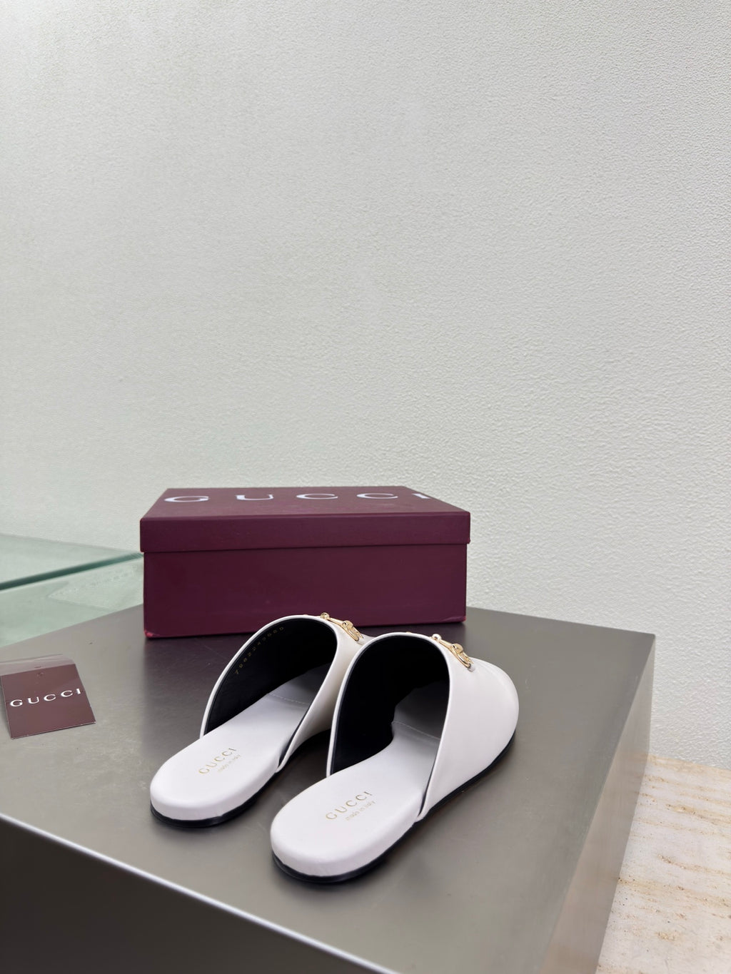 White mule shoes, open back view with gold horsebit detail