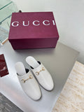 White mule shoes with gold horsebit detail and black insole, pair on box