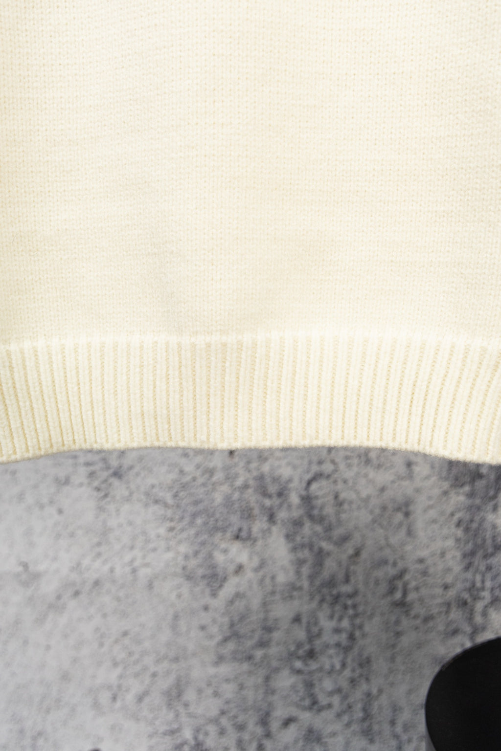 Ivory knit sweater hem with ribbed band detail