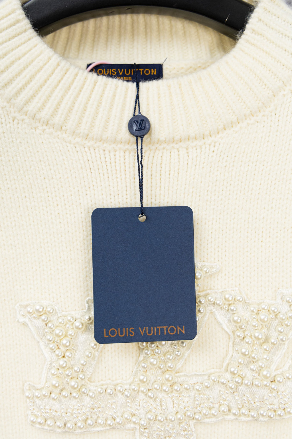 Ivory knit sweater front with beaded trim and hanging Louis Vuitton tag